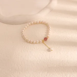 Detail view of natural freshwater pearl bracelet with pink crystal and gold pendant