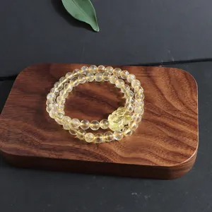 Macro detail of natural citrine lemon quartz beaded bracelet with a carved Pixiu charm