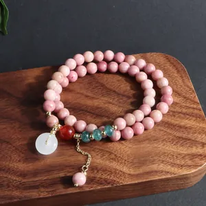Primer plano de pulsera de piedra natural de doble hebra con hebilla Ping'an y cuentas de esmeralda