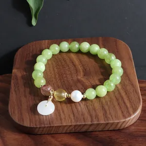 Detailansicht eines grünen Perlenarmbands im neuen chinesischen Stil mit Jade-Anhänger.