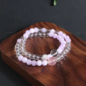 Detailed view of natural lavender and clear quartz crystal beaded bracelets on wood