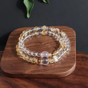 Close-up detail view of a double-layer natural crystal bead bracelet on a wooden tray