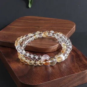 Detailed view of natural crystal bead bracelets displayed on a premium wooden block.
