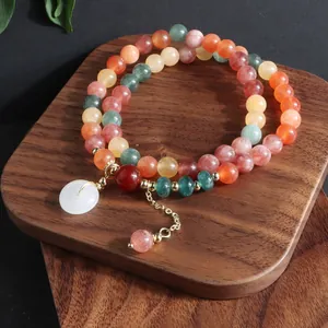 Vista detallada de pulsera de piedras naturales multicapa con colgante de jade blanco