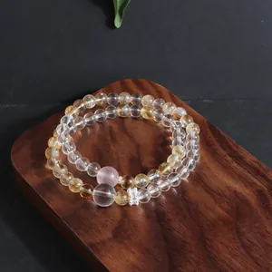 Macro view of a natural crystal bead bracelet on a walnut wood tray