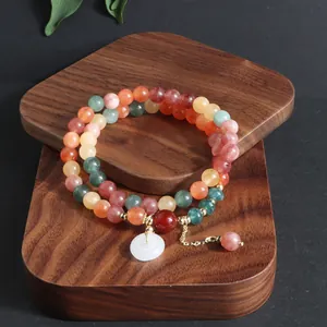 Detalle de pulsera de piedra natural de varias vueltas con colgante Ping'an Kou de jade