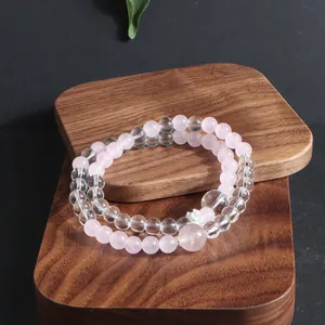 Elegant natural pink rose quartz and clear crystal beaded bracelet set on wooden blocks