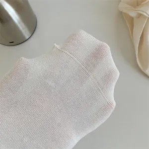 Gros plan de chaussettes en résille blanche respirante montrant la texture et la couture.