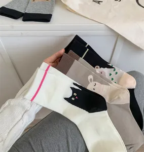 Gros plan de motifs d'illustrations de chat et d'ours mignons sur des chaussettes.