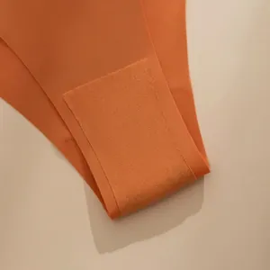 Detailansicht des atmungsaktiven Baumwollzwickels der nahtlosen orangefarbenen Unterhose