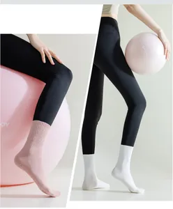 Detailed view of pink and white anti-slip yoga socks with silicone grip dots