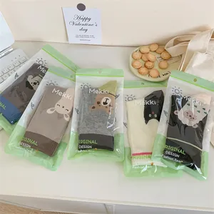 Lot de cinq paires de chaussettes mignonnes avec motifs d'animaux en sachets verts.