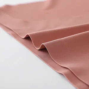 Detailopname van de gladde roze ijszijde stof van een dames T-back onderbroek.