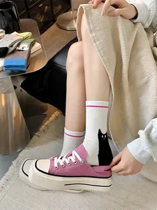 Gros plan de chaussettes blanches à motif chat avec des baskets roses à plateforme