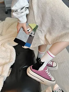 Vue détaillée de chaussettes chat mignon portées avec des baskets compensées violettes.