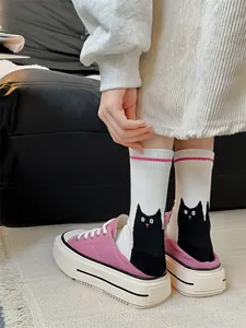 Vue détaillée de chaussettes blanches avec chat noir mignon et rayure rose