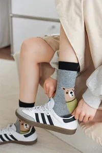 Chaussettes grises à mi-mollet avec motif ours de dessin animé portées avec des baskets