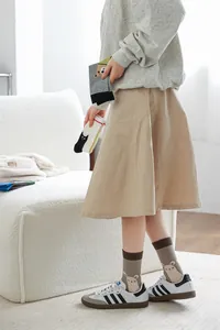 Détail d'une femme portant des chaussettes mi-hautes à motif lama avec baskets blanches