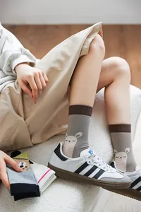 Détail rapproché de chaussettes à illustrations d'animaux mignons avec baskets blanches