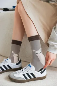 Détail d'une illustration d'alpaga sur des chaussettes grises portées avec des baskets