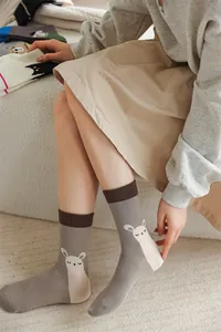 Vue détaillée de chaussettes mi-mollet grises avec motif alpaga portées par un mannequin
