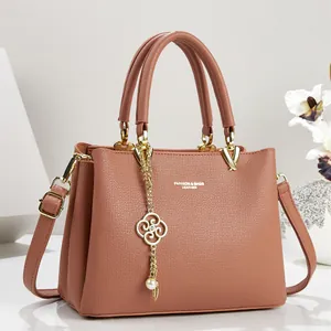 Detail showing elegant dusty rose leather texture and decorative gold flower pearl charm