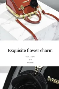 Dettaglio del ciondolo a fiore decorativo su borsa in pelle verniciata lucida