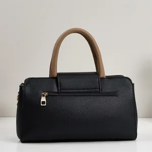 Vue arrière du sac à main en cuir noir avec poignées marron et détail de zip doré