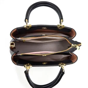 Detailed interior view showing multiple compartments and golden zippers of a black handbag