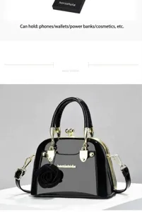 Elegante borsa a mano in vernice nera con un raffinato ciondolo a fiore e finiture dorate