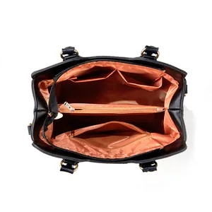 Detail view showing the organized orange interior of a black handbag with multiple compartments