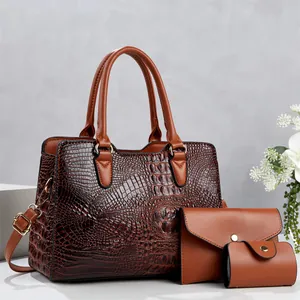 Close-up detail of a brown three-piece handbag set with textured crocodile pattern finish