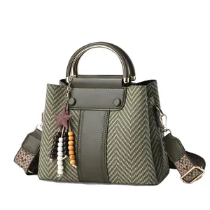 Elegante bolso de mano verde oliva con patrón de espiga y accesorio de estrella.