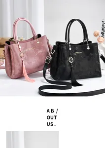 High-quality detail of elegant pink and black floral pattern handbags with decorative tassels
