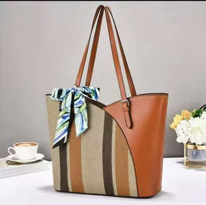 Detailed view of a large patchwork tote bag with striped canvas and decorative silk scarf