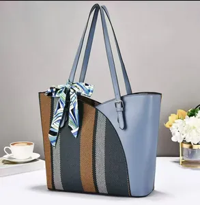 Stylish large capacity patchwork tote bag with decorative blue silk scarf on white table.