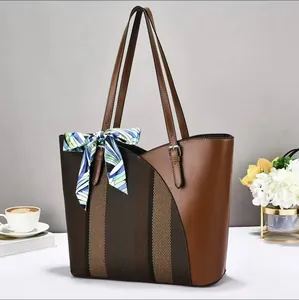 Close-up detail of a large capacity brown patchwork tote bag with a decorative silk scarf.