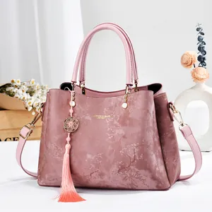 Elegant pink patterned handbag with decorative tassel and top handle
