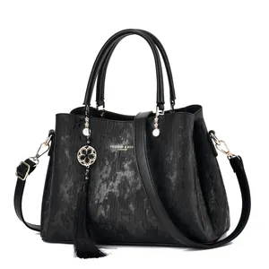 Elegant black textured women's handbag featuring a decorative tassel and adjustable strap