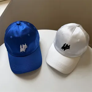 Pair of royal blue and white satin baseball caps with cat embroidery and wide brim