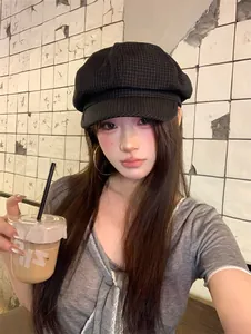 Close-up of woman wearing a black plaid retro newsboy hat in a stylish casual setting
