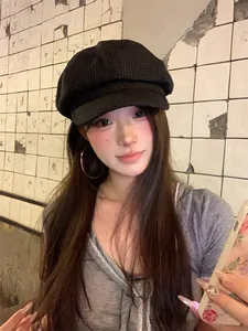 Stylish black checkered newsboy hat for women with retro octagonal design on model