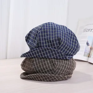 Nahaufnahme von blau und braun karierten Schiebermützen auf einem Holztisch