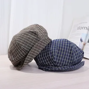 Detailansicht von zwei klassischen karierten Schiebermützen in Braun und Dunkelblau.