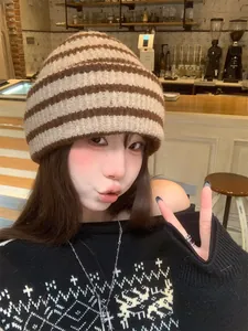 Close-up of a vintage striped knitted beanie in brown and beige colors worn in a cafe setting