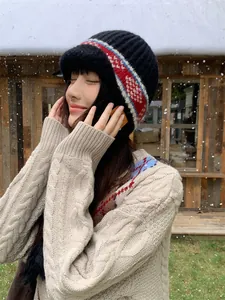 Model wearing a vintage jacquard knit ear protection hat in a snowy outdoor setting