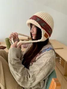 Detail of a woman wearing a vintage jacquard knitted ear-protection hat in a cozy setting.