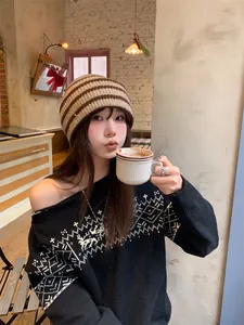 Asian woman in retro brown striped knit beanie hat holding a coffee cup in cafe