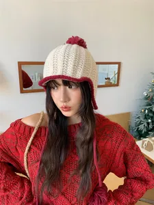 Close-up of a cute color-block knit hat with a pompom and ear protection