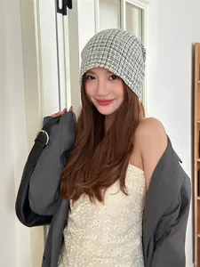 Stylish model wearing a Korean style black and white plaid knit beanie hat in a chic room